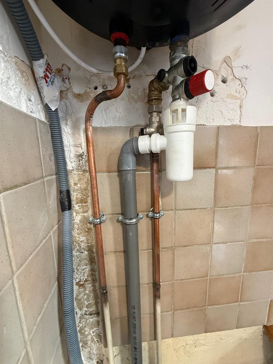 Raccords en cuivre et groupe de sécurité sous un chauffe-eau